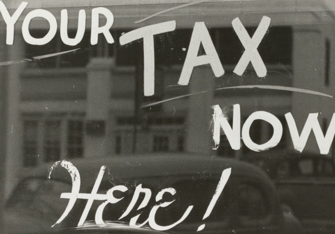 Ihre Steuern Fensterschriftzug: "Ihre Steuern jetzt hier!" mit nostalgischem Hintergrund.
